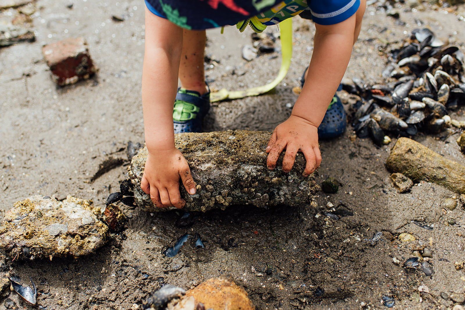 Kid lifting rock at Anvil Retreat