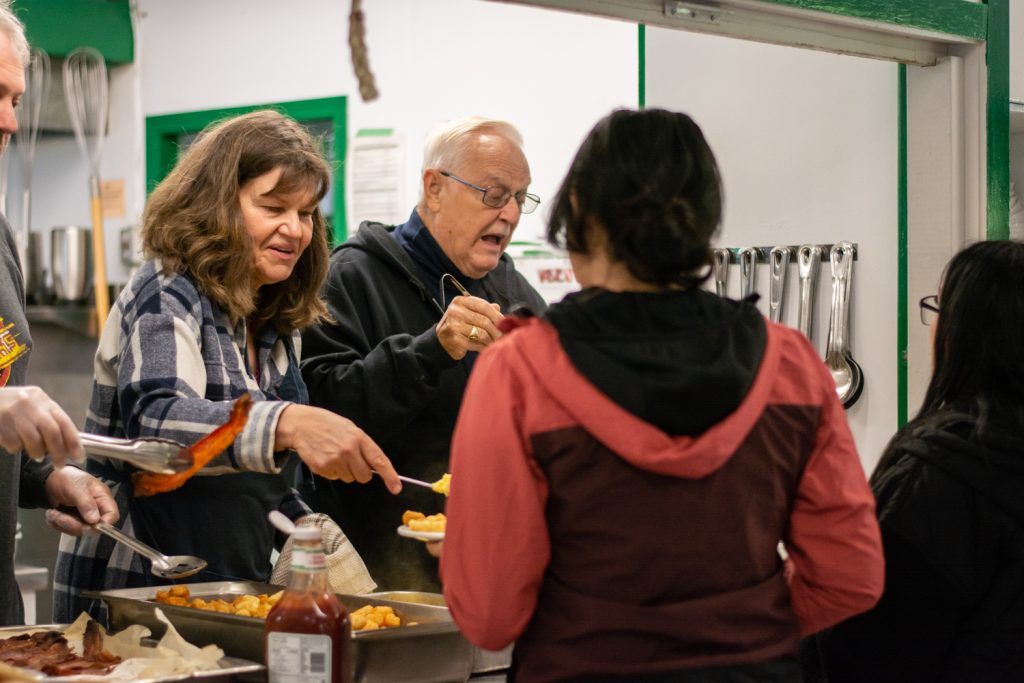 Serving food at the dining hall at Anvil Retreat